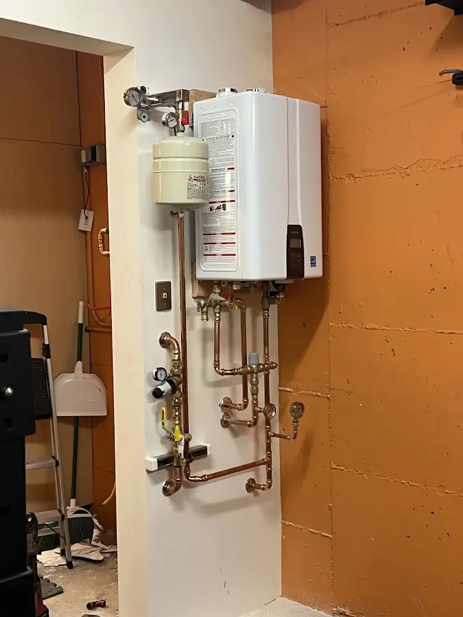 Plumbing technician inspecting water heater connections in Jonesboro